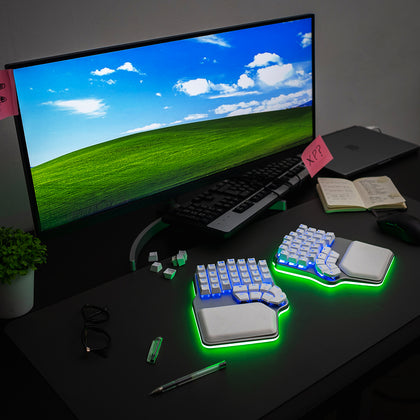 Silver Dygma Defy with white keycaps and green and blue RGB